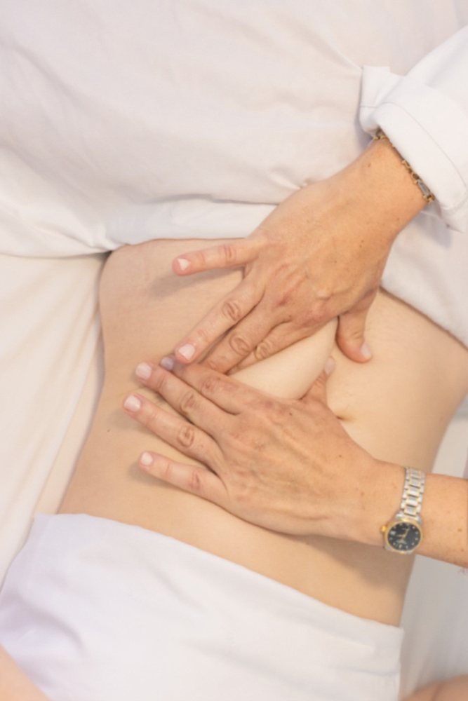 A therapist working the abdomen by hand during a session